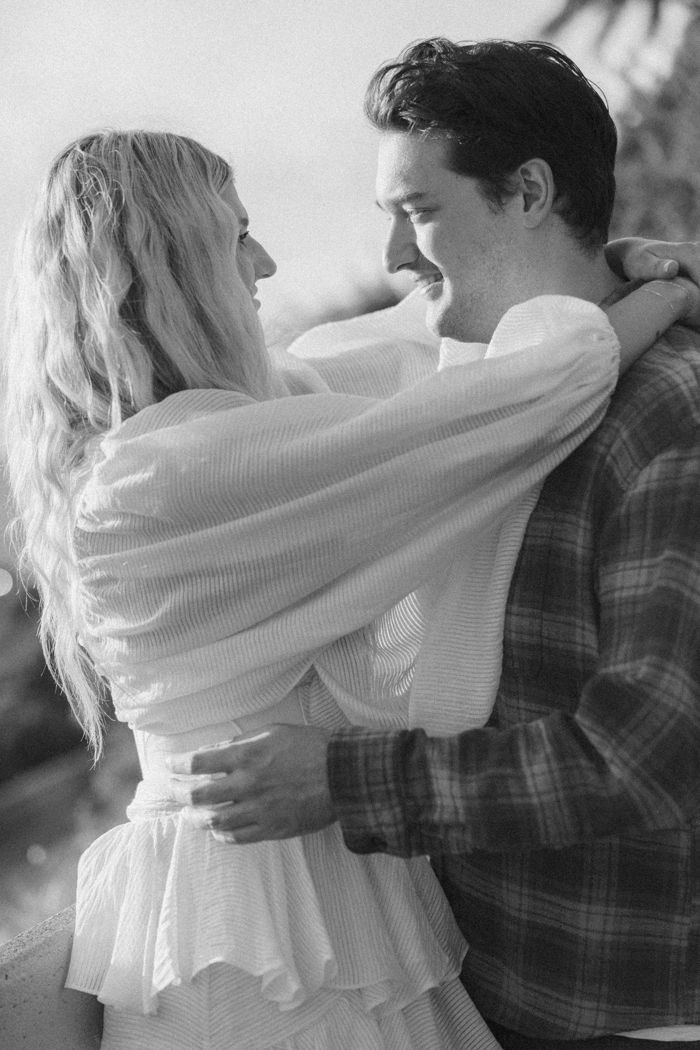 Jamie and Sean embracing and laughing together, in black and white